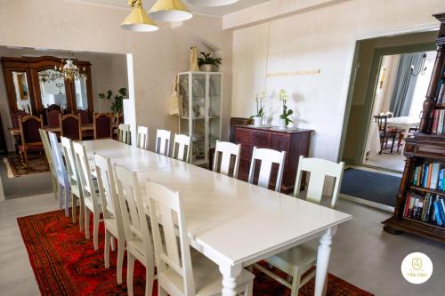 a dining room with a white table and chairs at Villa Eden - Design-Sea-Pool-Sauna in Kemionsaari