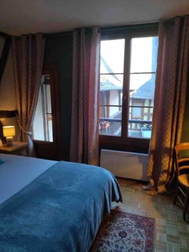 une chambre avec un lit bleu et une fenêtre dans l'établissement Appartement centre historique quartier cathédrale, à Bourges