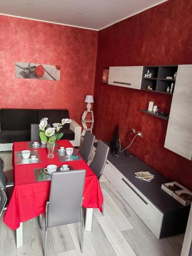 a red dining room with a table and chairs at Il giglio bianco in Ischia di Castro