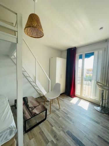 um quarto com uma escada e uma cadeira num quarto em Petit Studio centre Joliette(1) em Marselha