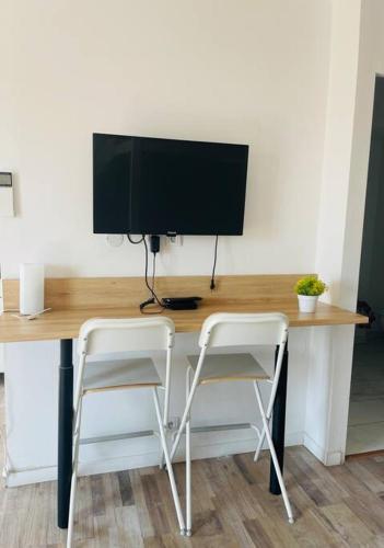- un bureau avec deux chaises et un ordinateur avec un moniteur dans l'établissement Petit Studio centre Joliette(1), à Marseille