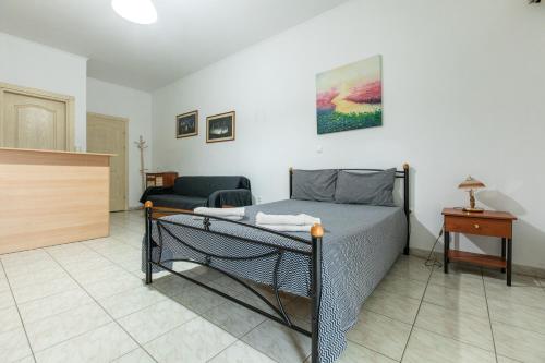 a bedroom with a bed and a couch at Central Cozy Apartment 3 in Sparti