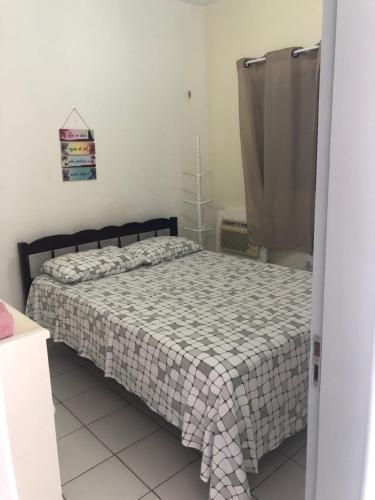 ein Schlafzimmer mit einem Bett mit einer karierten Decke in der Unterkunft Betesda 2197E KITNET in São Luís