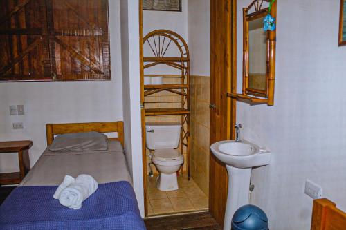 Casa Sua--Cozy 3 Bedroom Dominical Beach Cottage with Pool في دومينيكال: حمام به سرير ومرحاض ومغسلة