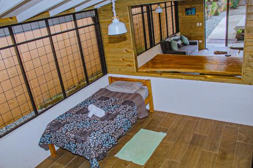 ein Zimmer mit einem Bett in der Mitte eines Zimmers in der Unterkunft Casa Sua--Cozy 3 Bedroom Dominical Beach Cottage with Pool in Dominical