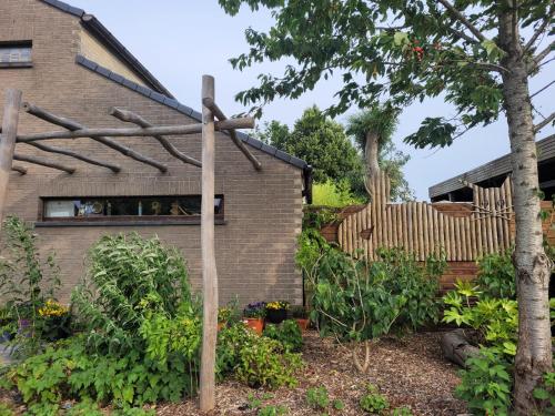 un jardin avec une clôture en bois devant une maison dans l'établissement Purple Papillon, à Heuvelland