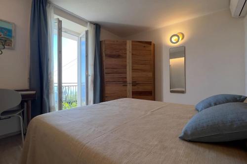 a bedroom with a bed with a window and a dresser at Casa Camelia in Volastra