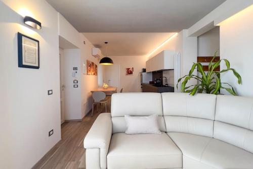 a living room with a white couch and a kitchen at Casa Camelia in Volastra