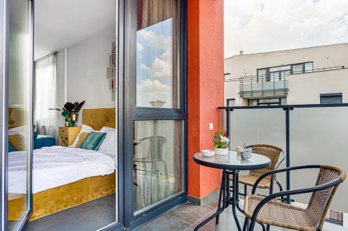 Un dormitorio con una cama y una mesa en el balcón. en Dodi Studio Compact en Arad