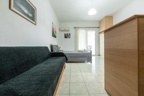a living room with a couch and a bed at Central Cozy Apartment 3 in Sparti