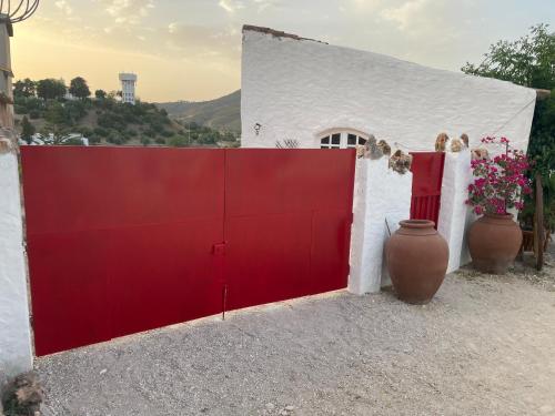 um portão vermelho em frente a um edifício branco em Monte Carrascal Guesthouse em Salir