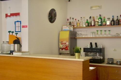 a bar with a counter with a refrigerator at Hotel Vila Verde in Castro Verde