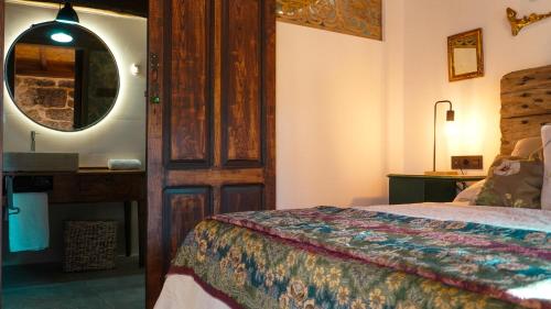 ein Hotelzimmer mit einem Bett und einem Spiegel in der Unterkunft Casa la Trinidad - Ribeira Sacra in Nogueira de Ramuin