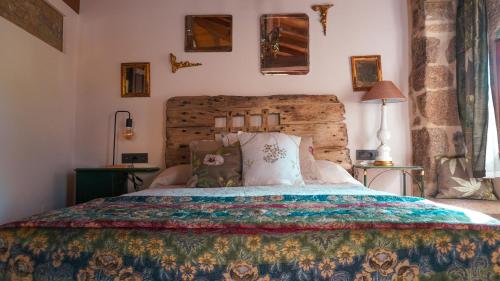 1 dormitorio con 1 cama con colcha colorida en Casa la Trinidad - Ribeira Sacra, en Nogueira de Ramuín