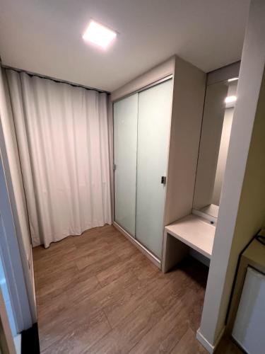 um quarto vazio com um armário e uma porta de correr em SG Apart Hotel em São Gonçalo do Rio Abaixo