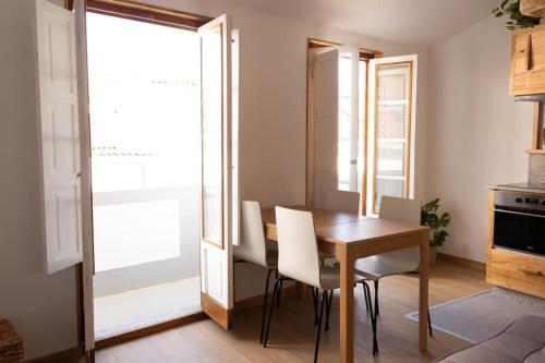 ein Esszimmer mit einem Holztisch und weißen Stühlen in der Unterkunft Ferreiros - Wood Design apartments in Puentedeume