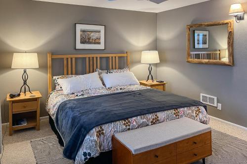 ein Schlafzimmer mit einem Bett, zwei Lampen und einem Spiegel in der Unterkunft 2404 Pitchfork in Jackson