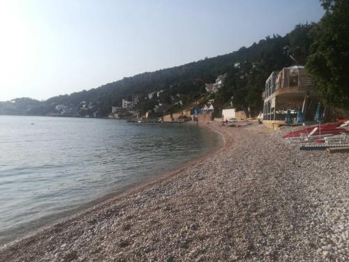 a beach with a rocky shoreline next to the water at Guest House Anna in Kruče