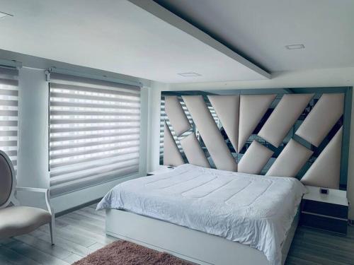 a bedroom with a bed and windows with blinds at Espectacular Casa De Lujo in Manizales
