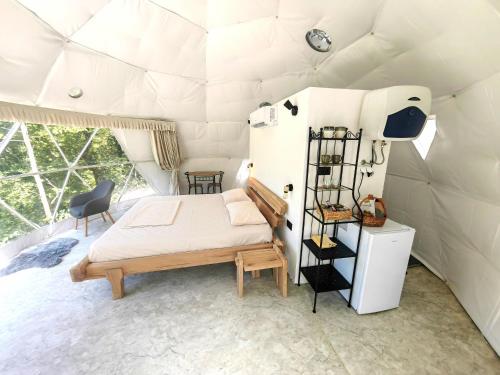 a bedroom in a tent with a bed and a shelf at ZEN Relaxing Village 