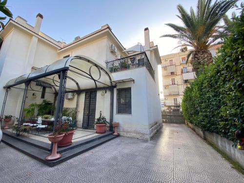 una grande casa bianca con patio e palma di Villa Luigi XVI a Taranto