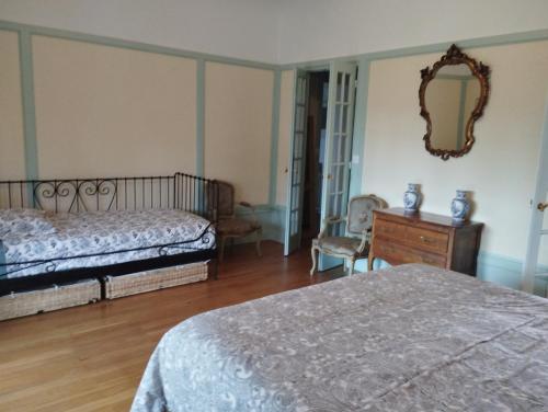 a bedroom with two beds and a dresser and a mirror at Ma Tranquillite in Courpière
