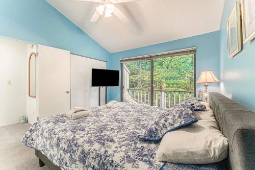 - une chambre bleue avec un lit et une fenêtre dans l'établissement Loggers Run, Unit 42, à Glen Arbor