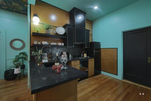 uma cozinha com armários pretos e um balcão preto em The Cat's Meow Apt 1 Sunset Heights em El Paso