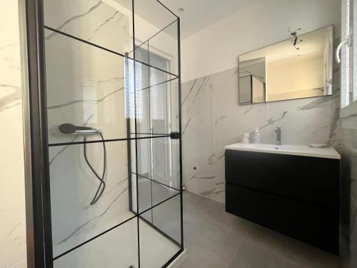 a bathroom with a glass shower and a sink at Villa 2 chambres rénovée Juillet 2023 - vue mer - parking privé in Grasse