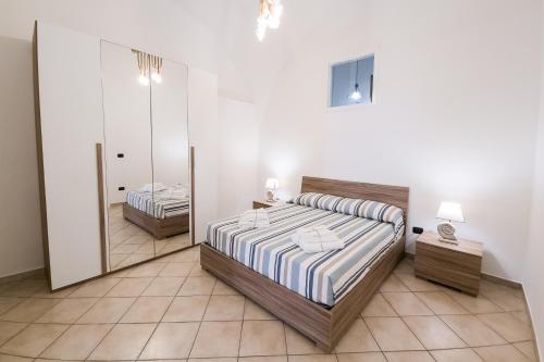 een slaapkamer met een bed en een spiegel bij Casa Della Nonna in Manfredonia