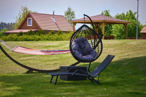 a hammock and a chair in a yard at Willa Mycyny oraz domki in Mycyny