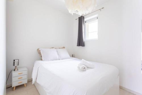 ein weißes Schlafzimmer mit einem weißen Bett und einem Fenster in der Unterkunft MARSEILLE T2 Central et lumineux in Marseille
