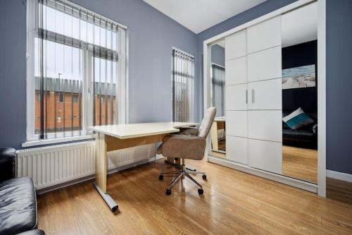 un bureau avec un bureau, une chaise et des fenêtres dans l'établissement Mega Flat Near Arndale City Centre, à Manchester