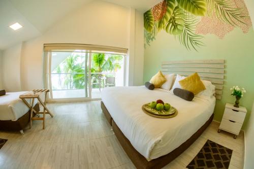 a bedroom with a bed with a bowl of fruit on it at Hotel Koray in San Andrés