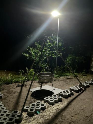 a street light and a bench in a park at night at Domek Survivalowy w Spale in Spała