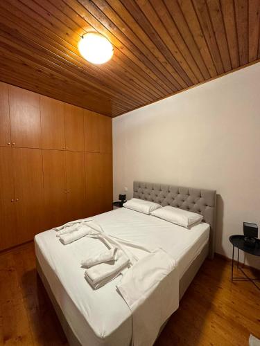 a bedroom with a large white bed with a wooden ceiling at Isabellas' home in Alepou