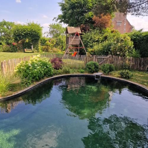 a swimming pool in a yard with a wooden fence at Gite avec piscine La Buissiere - Fernelmont in Pontillas