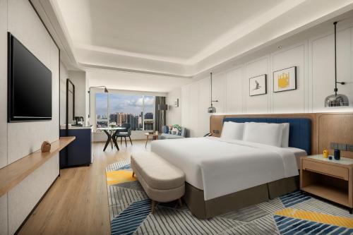 a hotel room with a large bed and a tv at voco Guangzhou Shifu, an IHG Hotel - Free shuttle between hotel and Exhibition Center during Canton Fair & Exhibitor registration Counter in Guangzhou