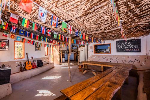 a room with benches and flags hanging from the ceiling at Casa Voyage Hostel in San Pedro de Atacama