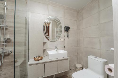 a bathroom with a toilet and a sink and a mirror at Kera Rooms in Tʼelavi
