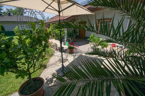 a patio with an umbrella and some plants at Northwest Studio Apartments in Klagenfurt