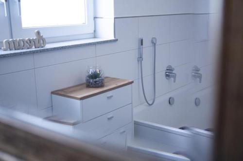 a white bathroom with a shower and a sink at Ferienwohnung Moseltraum in Müden