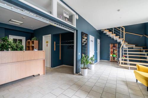 a lobby with blue walls and stairs in a store at Avanti apgyvendinimas-restoranas in Biržai