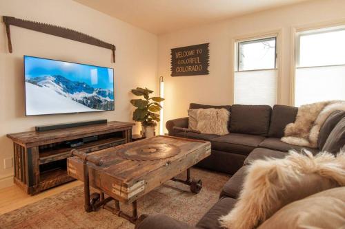 a living room with a couch and a flat screen tv at Premier Downtown Telluride Condo with Pool, Hot Tub & Parking in Telluride