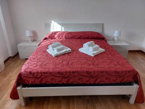 um quarto com uma cama vermelha e toalhas em Kalisa Home, B&B e Casa Vacanza Palermo em Capaci