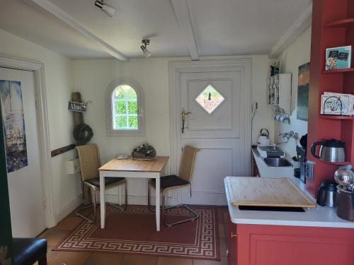 a kitchen with a table and chairs in a room at Ahoi Husum, anlegen und wohlfühlen in Husum