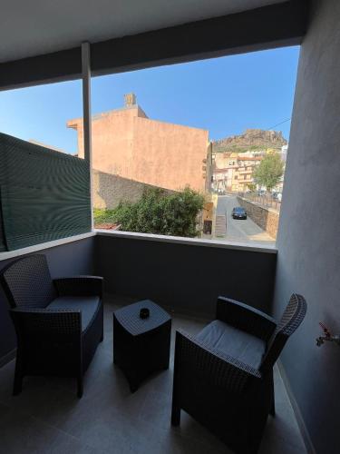 a balcony with two chairs and a large window at MaLuNa in Castelsardo