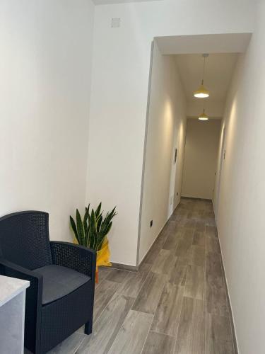 a living room with a chair and a hallway at MaLuNa in Castelsardo