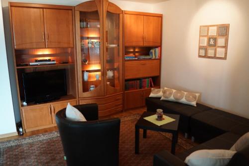 a living room with a couch and a tv at Fuchsia Lodge in Waldstetten