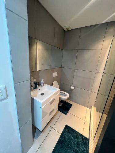 Sky View Escape في ويندهوك: حمام مع حوض أبيض ومرحاض